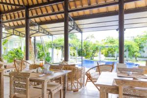 a restaurant with tables and chairs and a pool at M-Apartment in Badung