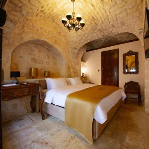una camera da letto con un grande letto in una stanza di pietra di Arangah Otel a Şanlıurfa