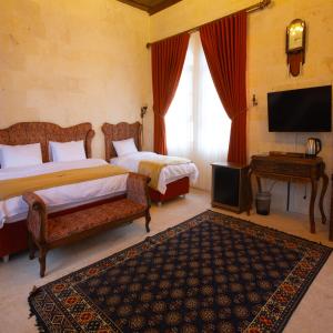 una camera da letto con due letti e una TV a schermo piatto di Arangah Otel a Şanlıurfa Altre 16 foto