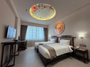 een hotelkamer met 2 bedden en een kroonluchter bij De Lush Pune in Pune