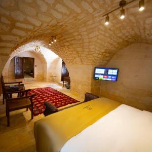 una camera da letto con un letto e una TV in una stanza di Arangah Otel a Şanlıurfa