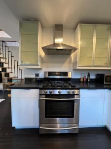 eine Küche mit einem Edelstahlherd und weißen Schränken in der Unterkunft Topanga Garden Paradise 1BR - in the Heart of PO Tract in Topanga