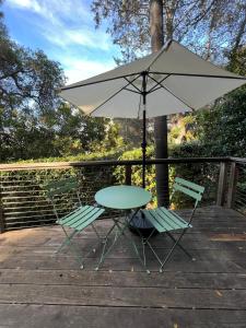 einen Tisch und zwei Stühle mit Sonnenschirm auf einer Terrasse in der Unterkunft Topanga Garden Paradise 1BR - in the Heart of PO Tract in Topanga + 11 Fotos