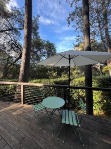 einen Tisch, Stühle und einen Regenschirm auf einer Terrasse in der Unterkunft Topanga Garden Paradise 1BR - in the Heart of PO Tract in Topanga