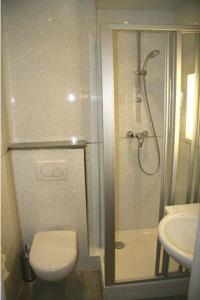 a bathroom with a shower and a toilet and a sink at Hotel Bellevue Saint-Lazare in Paris