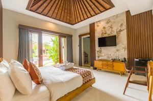 une chambre avec un grand lit et une télévision dans l'établissement Kesumasari Living, à anur