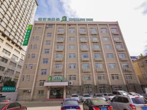 a large building with cars parked in a parking lot at Jinjiang Inn Style Shenyang The Palace Huaiyuan Gate in Shenyang