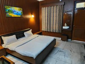 een slaapkamer met een groot bed en een wastafel bij Satkar palace hotel 