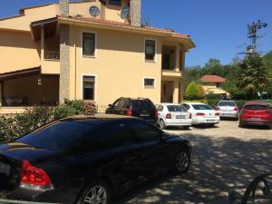 a black car parked in a parking lot in front of a house at Sarikonaklar Garden Village in Şile