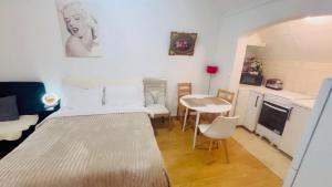 ein Schlafzimmer mit Bett und Tisch und eine Küche in der Unterkunft Appartement avec terrasse in Drancy