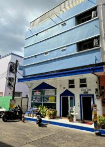 a blue building with a motorcycle parked in front of it at City Inn Udonthani in Udon Thani