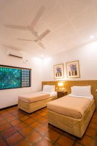 Dos camas en una habitación con dos ventanas. en Lisland Rainforest Resort, en Urdaneta 13 fotos más