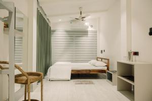 a bedroom with a bed and a green curtain at Vanilla Country in Dibrugarh