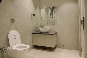 a bathroom with a white toilet and a sink at Vanilla Country in Dibrugarh +12 photos