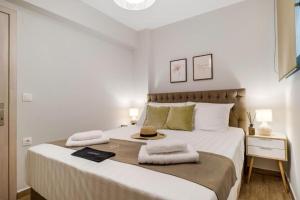 een witte slaapkamer met een groot bed met handdoeken erop bij Ionian Sea View Luxury Apartments in Nikiana