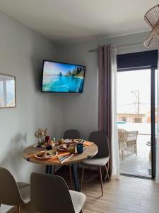 een kamer met een tafel en stoelen en een televisie aan de muur bij Ionian Sea View Luxury Apartments in Nikiana