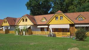 una gran casa amarilla con bicicletas estacionadas en el patio en Soncnica Apartment, en Moravske Toplice