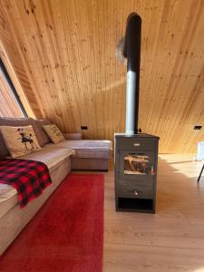 a living room with a fireplace and a couch with a stove at A-frame Wonder Mountain Chalet in Mestia