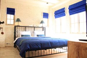 a bedroom with a bed with blue sheets and windows at M-Apartment in Badung +23 photos