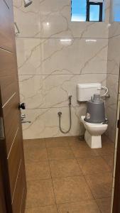 a bathroom with a toilet and a stone wall at G K Residency in Mangalore