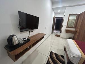 a bedroom with a flat screen tv on the wall at G K Residency in Mangalore +22 photos