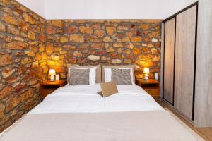 een slaapkamer met een bed met een boek erop bij Stone House Edipsos in Loutra Edipsou +94 foto's