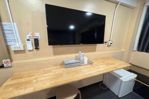 einen Schreibtisch mit einem großen TV an der Wand in der Unterkunft Pratunam Family House in Ban Nong Chaeng + 69 Fotos