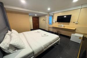 ein Hotelzimmer mit Bett und Schreibtisch in der Unterkunft Pratunam Family House in Ban Nong Chaeng