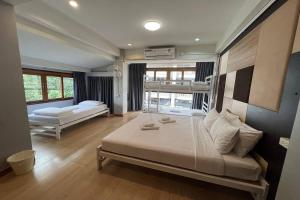 ein Schlafzimmer mit zwei Betten und einem großen Fenster in der Unterkunft Pratunam Family House in Ban Nong Chaeng