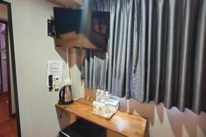 einen Fernseher auf einem Schreibtisch in einem Zimmer in der Unterkunft Pratunam Family House in Ban Nong Chaeng