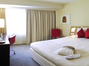 a hotel room with a large white bed with red pillows at Novotel Sheffield Centre in Sheffield