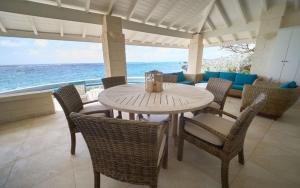 a table and chairs with a view of the ocean at Maltese Falcon - by ZenBreak in Saint Philip