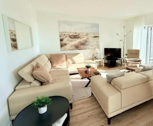 ein Wohnzimmer mit Sofa und Tisch in der Unterkunft Luxury Condo with Pool and River View in Baie-Saint-Paul
