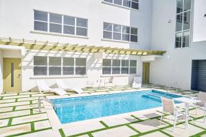 een zwembad met stoelen en een gebouw bij Coral Beach 204 - by ZenBreak in Saint Peter