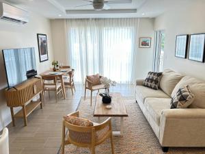 een woonkamer met een bank en een tafel bij Coral Beach 204 - by ZenBreak in Saint Peter