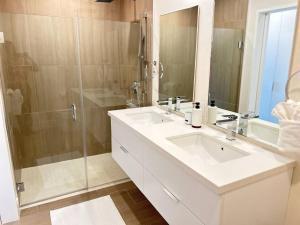 een badkamer met twee wastafels en een douche bij Coral Beach 204 - by ZenBreak in Saint Peter