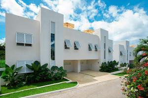 a white building with windows and plants at The Nest Garden Grove - by ZenBreak in Saint James