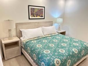 a bedroom with a bed with a green comforter at Coral Beach 204 - by ZenBreak in Saint Peter