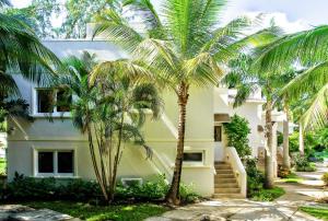 una casa bianca con palme di fronte di KingsGate 1 - by ZenBreak a Saint Peter