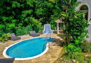 una piscina in un cortile con tavolo e sedie di KingsGate 1 - by ZenBreak a Saint Peter