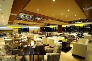 ein Restaurant mit weißen Stühlen und Tischen in einem Gebäude in der Unterkunft Huangshan Xuanyuan International Hotel in Tangkou