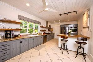 a large kitchen with blue cabinets and a counter at Kyalami - by ZenBreak in Saint James