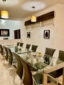 a dining room with a glass table and chairs at Harbour View - by ZenBreak in Saint Michael