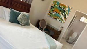 a bedroom with a bed and a painting on the wall at Hope Winds - by ZenBreak in Christ Church