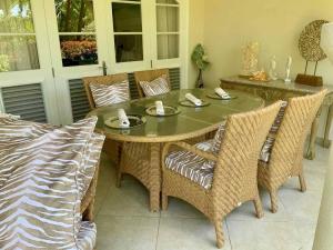 tavolo da pranzo con sedie in vimini, tavolo e sedie a sdraio di Sugar Breeze B106 - by ZenBreak a Saint James Altre 13 foto