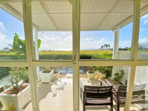 a screened in porch with a table and chairs at ZenBreak The Gem in Saint Philip