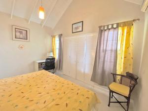 a bedroom with a bed and a chair and a window at ZenBreak The Gem in Saint Philip