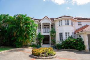 una grande casa bianca con palme e fiori di Marzalea - by ZenBreak a Saint James