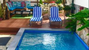 two chairs and a swimming pool in a backyard at Villa De Lasannta - by ZenBreak in Christ Church