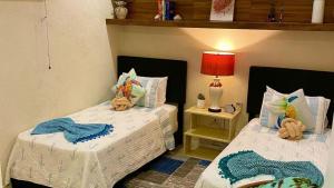 a bedroom with two beds with stuffed animals on them at Villa De Lasannta - by ZenBreak in Christ Church